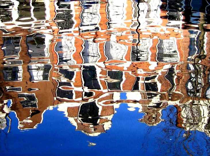 Dutch houses reflected in canal in Amsterdam