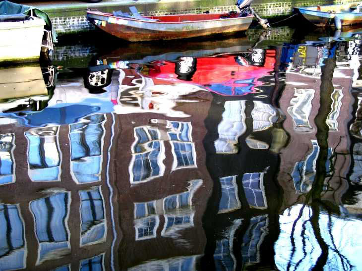 Red car and windows reflected in canal, Amsterdam