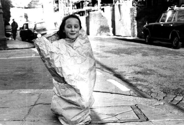 Black & white photograph. Girl in bag, Hammersmith, London